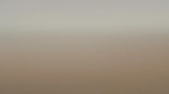 Vue grand angle d'une plage basque vide au lever du soleil avec des planches de surf installées sur le sable et l'océan Atlantique calme en arrière-plan