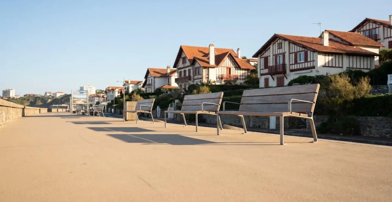 Promenade piétonne accessible le long du front de mer de Biarritz avec villas basques en arrière-plan, bancs contemporains, chemin lisse sans obstacles, lumière naturelle