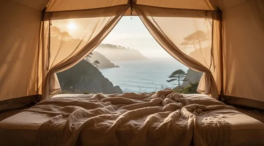 Interieur cosy d'une tente de camping a Biarritz avec un matelas confortable au petit matin face a l'ocean Atlantique